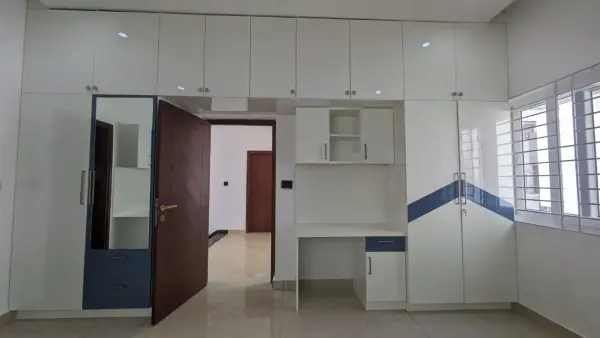 HSR Layout home interior – bedroom with white and navy wardrobe and study desk unit by Prestige Craft Interiors