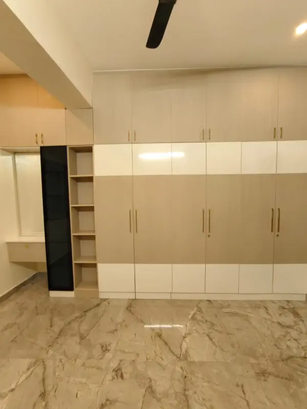 HSR Layout home interior – bedroom wardrobe with wooden louvre partition and open shelving by Prestige Craft Interiors