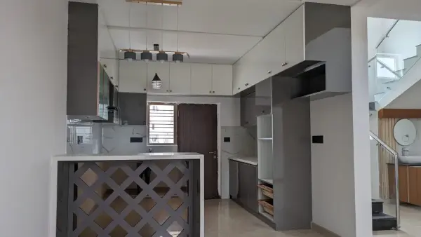 HSR Layout home interior – kitchen with overhead cabinets, pendant lighting and jaali partition by Prestige Craft Interiors