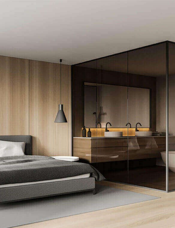 Modern bedroom interior design with glass-partitioned ensuite bathroom by Prestige Craft Interiors