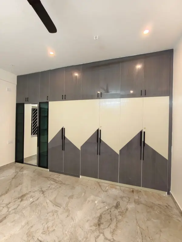 Sarjapur Road home interior – bedroom wardrobe with triangle pattern doors and mirror unit by Prestige Craft Interiors